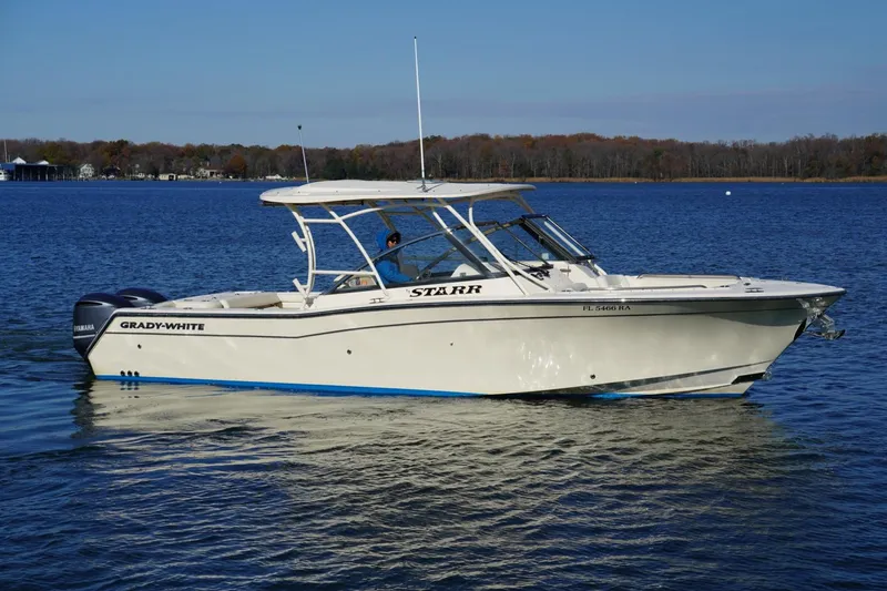 Slide: The Image of 2015 Grady-White Freedom 307 boat on calm water, side view. - 7