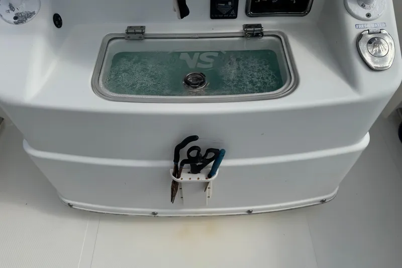 Slide: The Image of 2018 NauticStar 2602 Legacy boat console with livewell and fishing tools. - 11