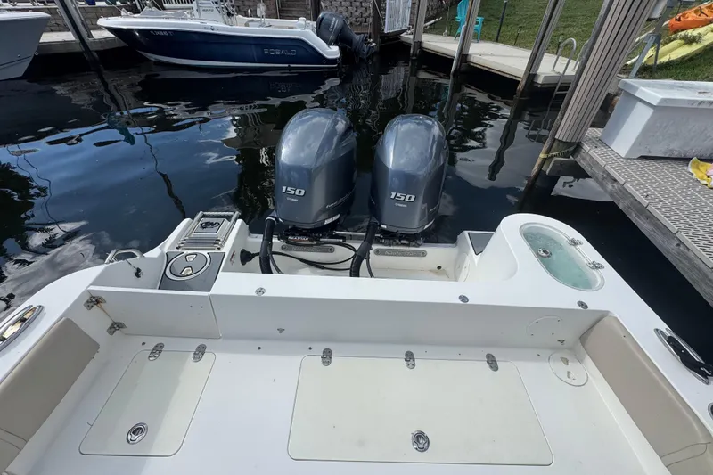 Slide: The Image of 2018 NauticStar 2602 Legacy boat with twin 150 horsepower engines docked at marina. - 4