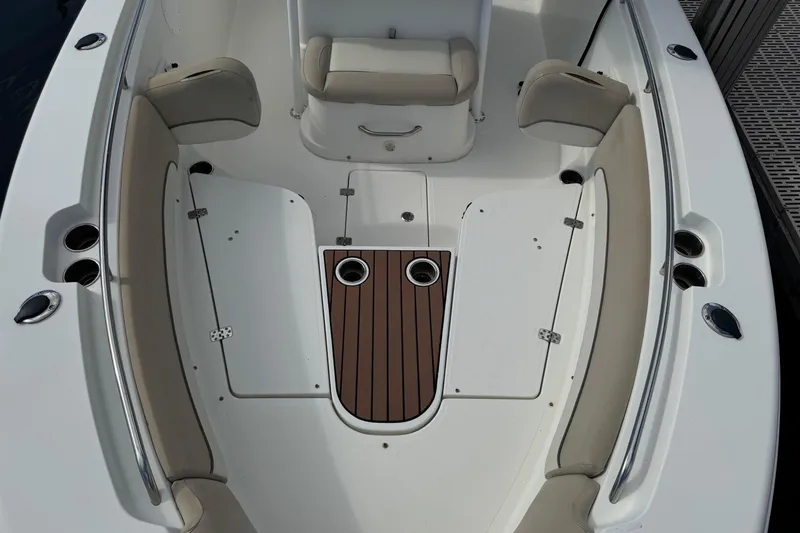 Slide: The Image of 2018 NauticStar 2602 Legacy boat interior with cushioned seating and wood accents. - 9