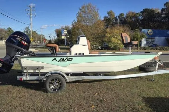 The Image of 2026 Avid 18 Rogue CC boat on trailer, parked outdoors with trees in background. - 1