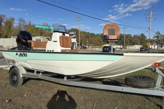 Slide: The Image of 2026 Avid 18 Rogue CC boat on trailer, parked outdoors under clear sky. - 6