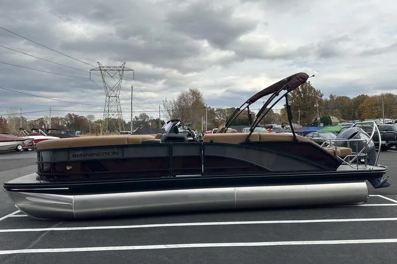 Slide: The Image of 2026 Bennington M Quad Bench 24 MSL pontoon boat in parking lot under cloudy sky. - 11