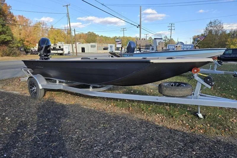 The Image of 2026 Avid 18 Commander boat on trailer, parked outdoors near a road. - 0