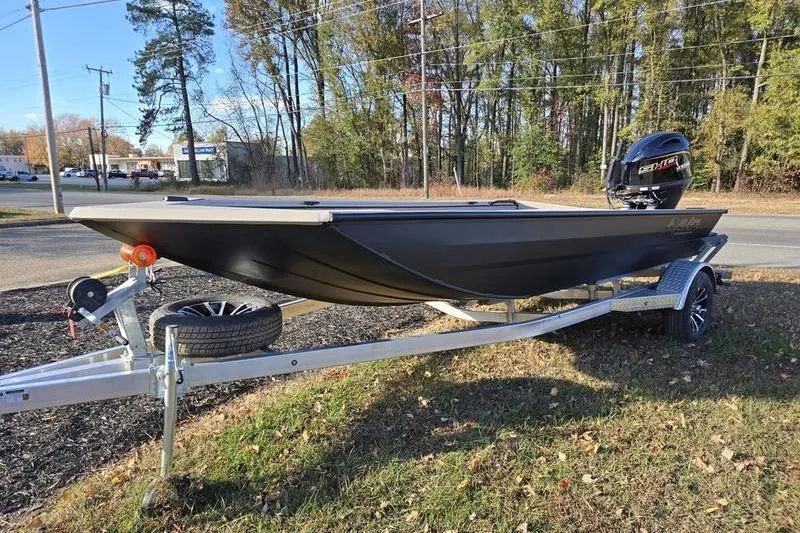Slide: The Image of 2026 Avid 18 Commander boat on trailer with outboard motor, parked outdoors. - 2