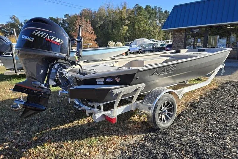 Slide: The Image of 2026 Avid 18 Commander boat on trailer, parked outdoors near buildings. - 5