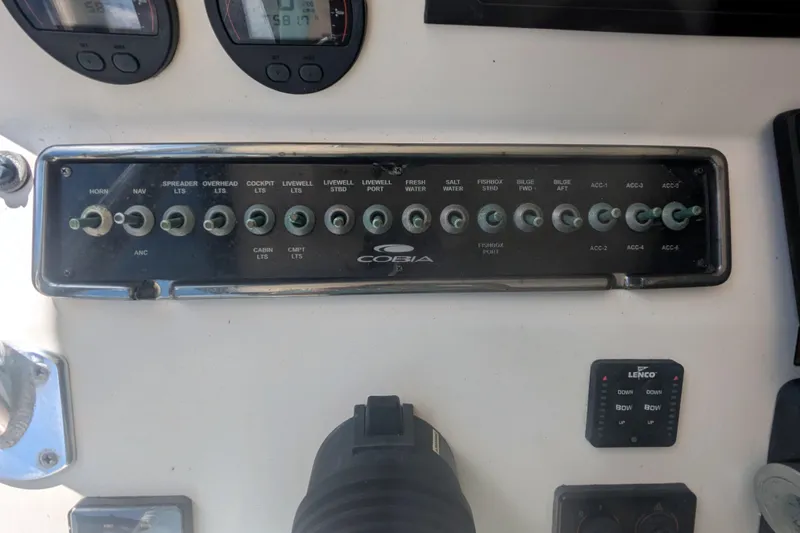 Slide: The Image of Control panel of a 2013 Cobia 296 Center Console boat with labeled switches. - 12