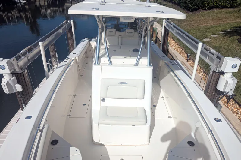 Slide: The Image of 2013 Cobia 296 Center Console boat docked, featuring spacious seating and sleek design. - 16