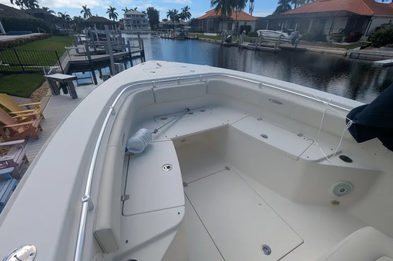 Slide: The Image of 2013 Cobia 296 Center Console boat docked in a scenic waterfront setting. - 19