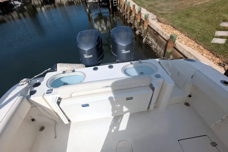 Slide: The Image of 2013 Cobia 296 Center Console boat with twin 300 engines docked by the water. - 24