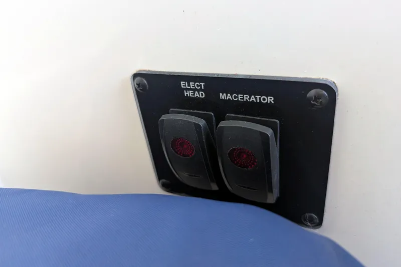 Slide: The Image of Control panel with switches for electric head and macerator on 2013 Cobia 296 Center Console. - 27