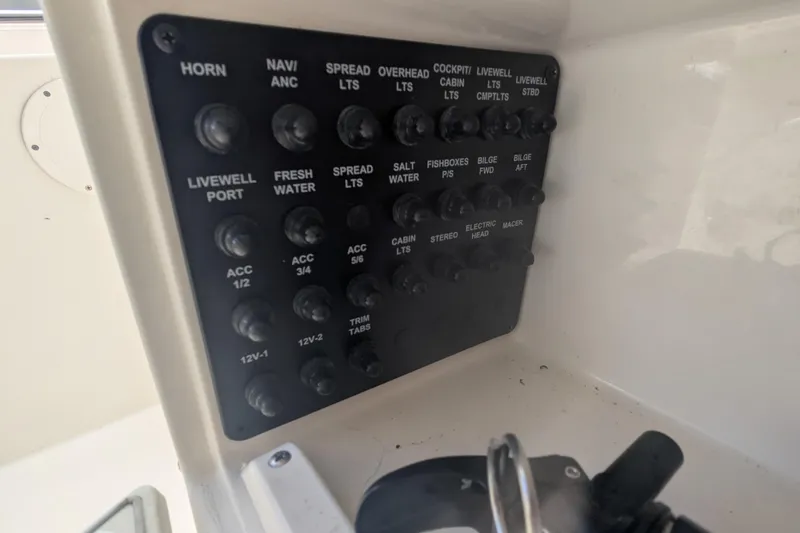 Slide: The Image of Control panel of a 2013 Cobia 296 Center Console boat with labeled switches. - 28