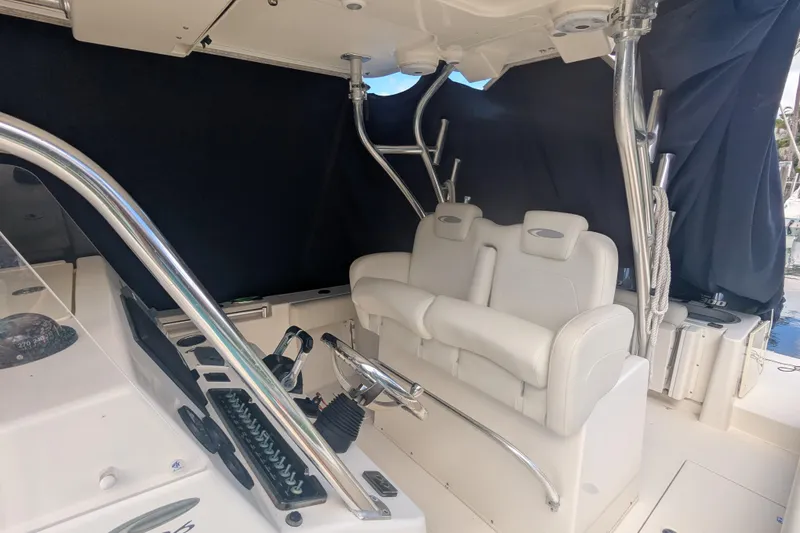 Slide: The Image of 2013 Cobia 296 Center Console boat interior with white seating and steering wheel. - 29