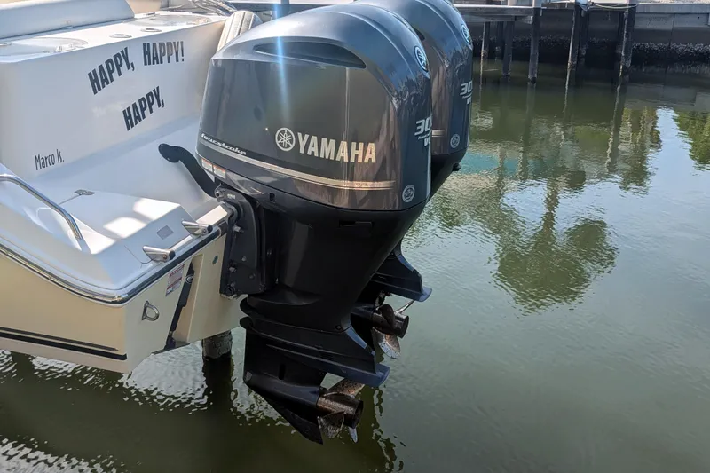 Slide: The Image of 2013 Cobia 296 Center Console with twin Yamaha outboard motors docked by water. - 6
