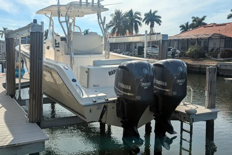 Slide: The Image of 2013 Cobia 296 Center Console boat with twin Yamaha 300 V6 engines on a lift. - 7