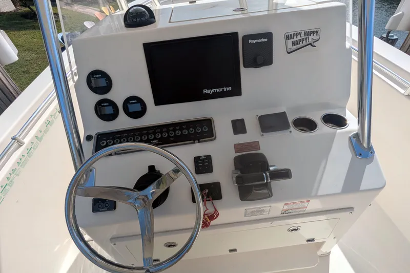 Slide: The Image of 2013 Cobia 296 Center Console boat dashboard with steering wheel and Raymarine electronics. - 9
