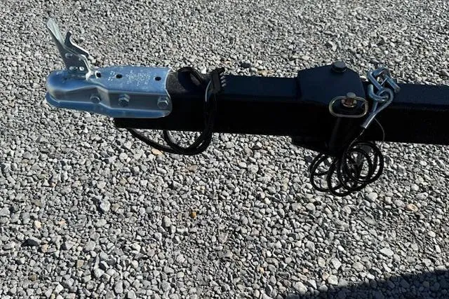 Slide: The Image of Trailer hitch of a 2026 Thor TIMBER HAMMER 1754 on gravel surface. - 6