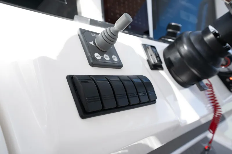 Slide: The Image of Control panel of 2026 Deep Impact 499 Sport Luxury Edition boat, featuring switches and joystick. - 52