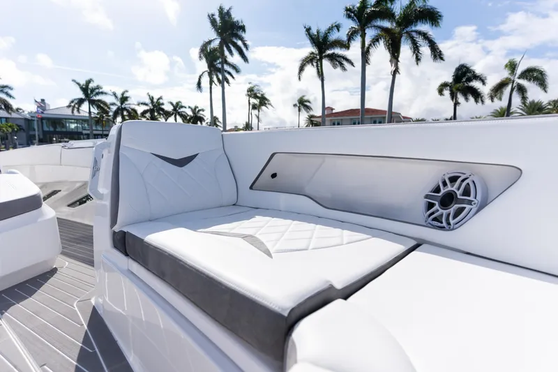 Slide: The Image of 2026 Deep Impact 499 Sport Luxury Edition boat interior with white seating and speaker. - 81