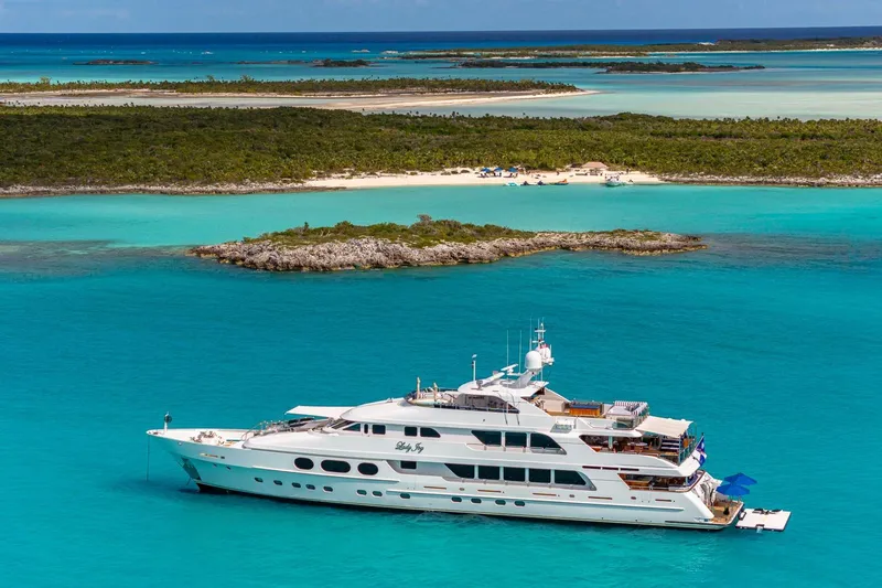 The Image of Luxurious 2007 Christensen Tri-Deck yacht anchored in turquoise waters near a tropical island. - 1