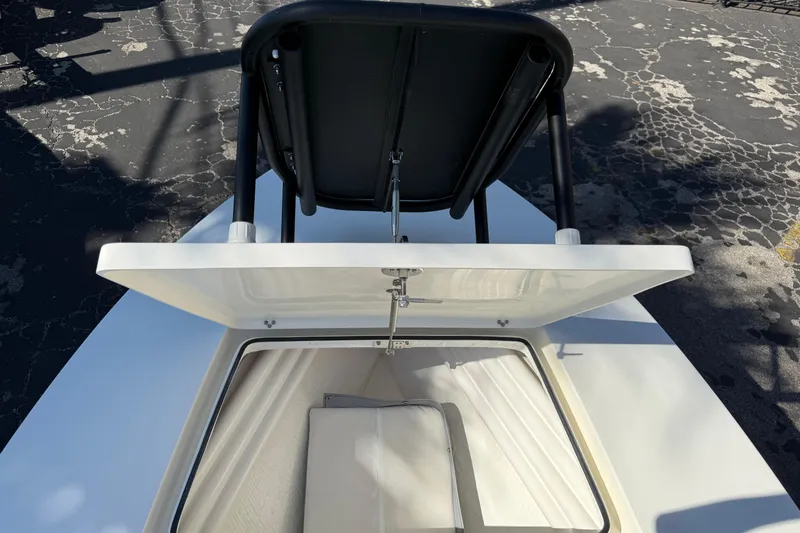 Slide: The Image of 2026 Maverick 17 HPX-S boat storage compartment with open lid and seat backrest. - 26