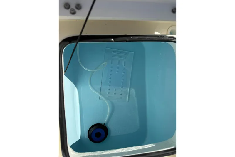 Slide: The Image of Livewell interior of 2026 Maverick 17 HPX-S boat, featuring blue lining and tubing. - 32