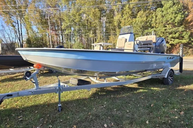 The Image of 2026 Avid 21 Fusion boat on trailer, parked on grass with trees in background. - 0