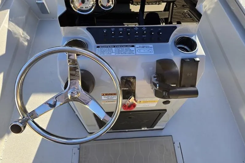 Slide: The Image of Steering console of 2026 Avid 21 Fusion boat with chrome wheel and control panel. - 12