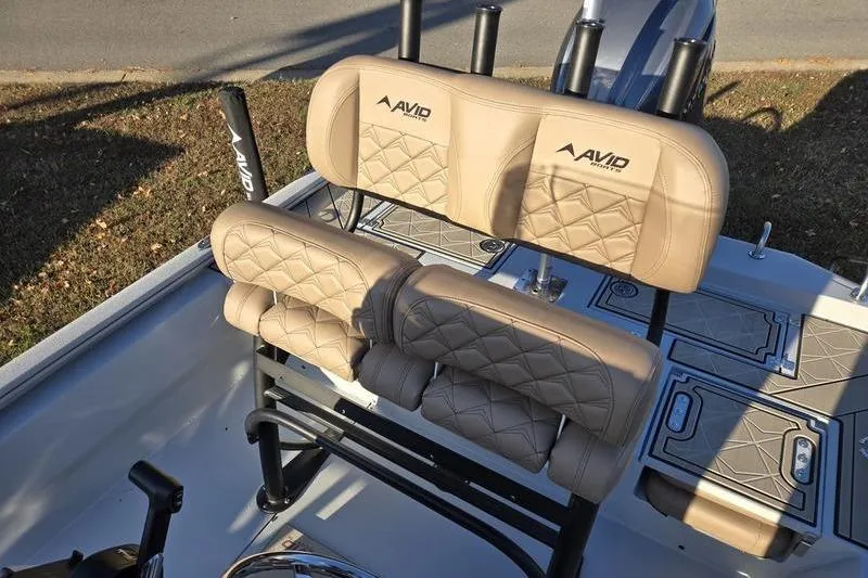 Slide: The Image of Avid 21 Fusion 2026 boat seats with beige quilted upholstery and rod holders. - 13
