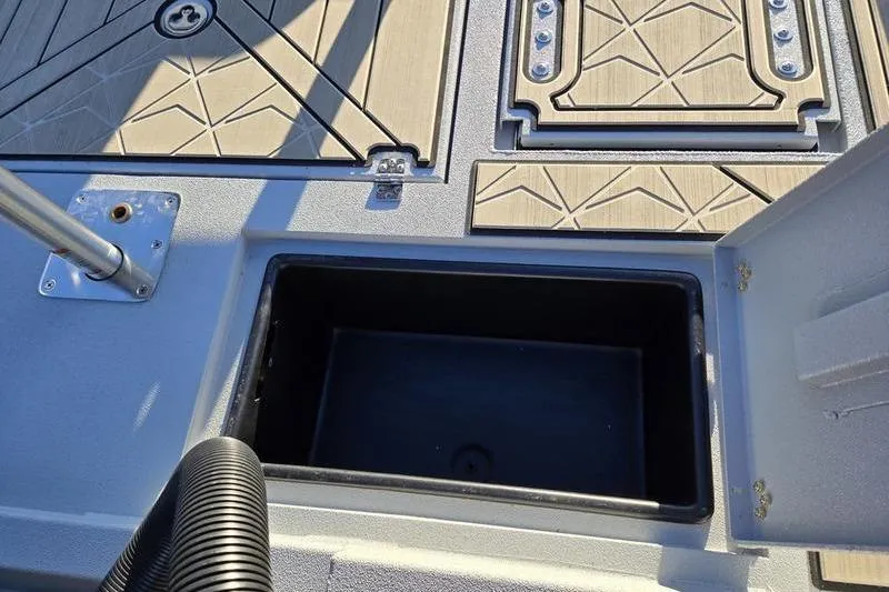 Slide: The Image of Avid 21 Fusion 2026 boat deck with open storage compartment and textured flooring. - 16