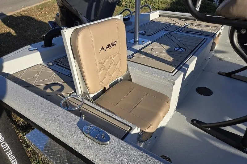 Slide: The Image of Avid 21 Fusion 2026 boat interior with beige seating and storage compartments. - 2
