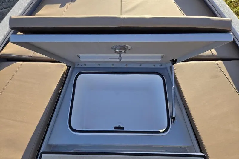 Slide: The Image of Open storage compartment on 2026 Avid 21 Fusion boat with cushioned seating. - 22