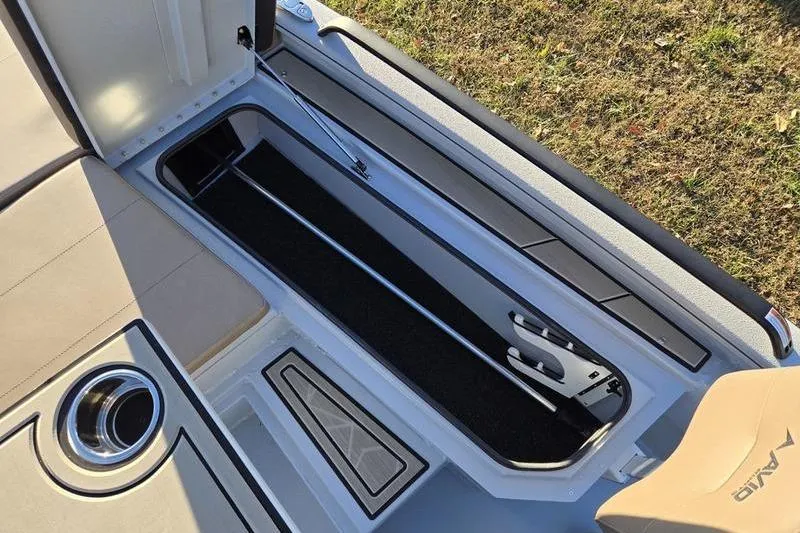 Slide: The Image of Open storage compartment in 2026 Avid 21 Fusion boat, featuring sleek design and cup holder. - 24
