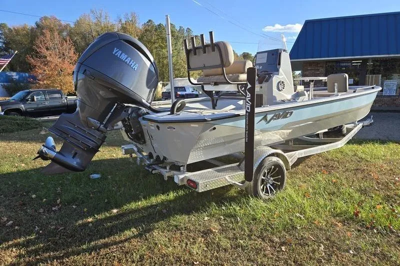 Slide: The Image of Avid 21 Fusion boat with Yamaha motor on a trailer, parked outdoors. - 8