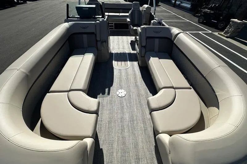 Slide: The Image of 2026 Bennington M Swingback 24 MSB boat interior with beige seating and motor view. - 12