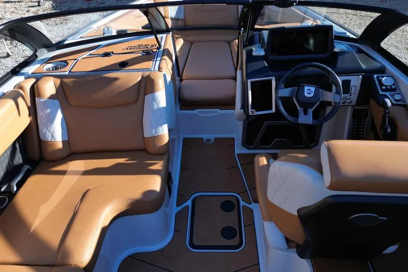 Slide: The Image of 2021 Malibu M220 boat interior with tan leather seats and modern dashboard. - 12