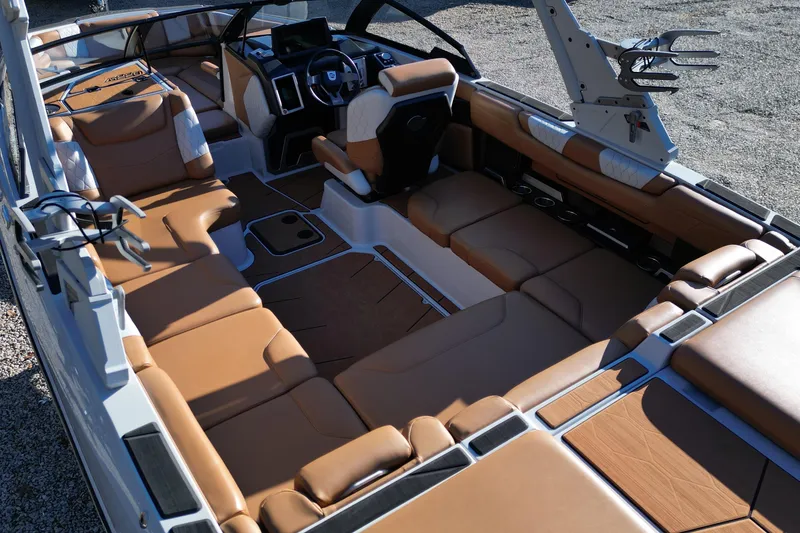Slide: The Image of 2021 Malibu M220 boat interior with luxurious tan seating and modern dashboard. - 15