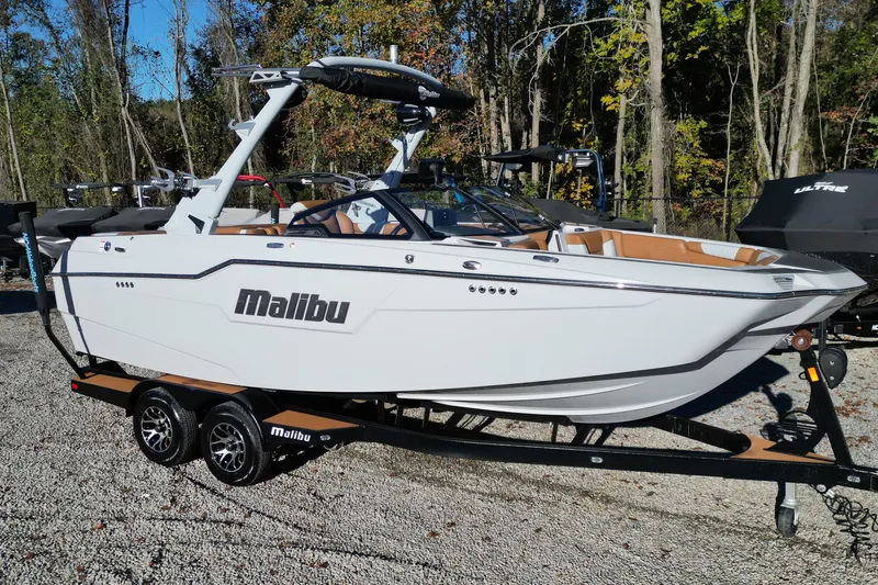Slide: The Image of 2021 Malibu M220 boat on trailer, white exterior, parked outdoors. - 16
