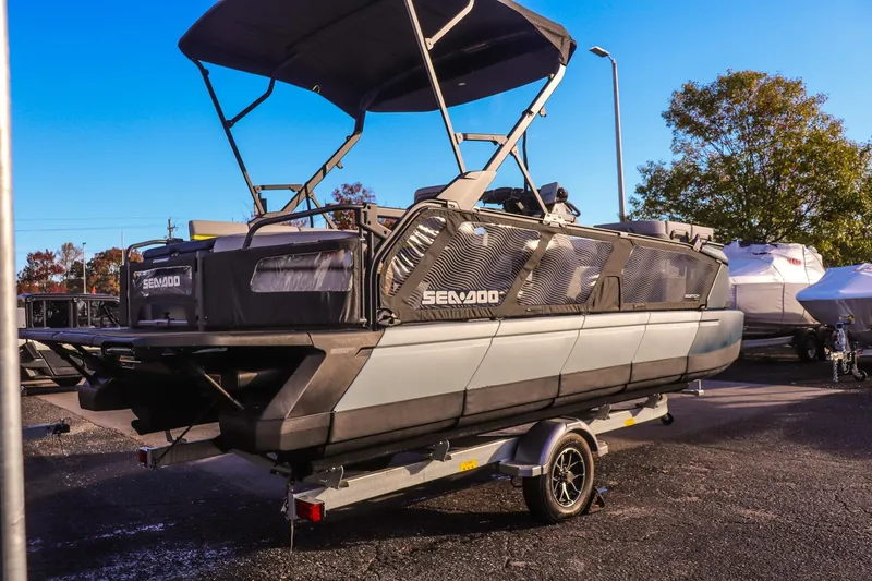 Slide: The Image of 2025 Sea-Doo Switch Cruise Limited 21 pontoon boat on trailer, parked outdoors. - 2