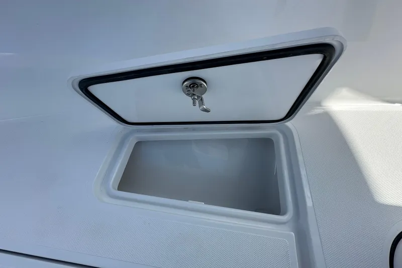Slide: The Image of Open storage compartment on 2026 Bluewater 25t boat with secure latch. - 11