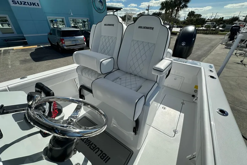 Slide: The Image of 2026 Bluewater 25t boat with dual seats and steering wheel, parked outdoors. - 15