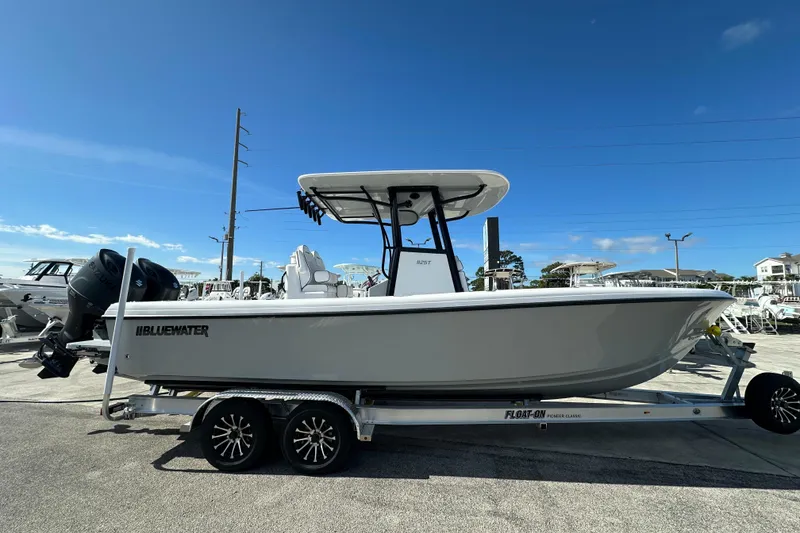 Slide: The Image of 2026 Bluewater 25t boat interior with rod holders and dual engines. - 16