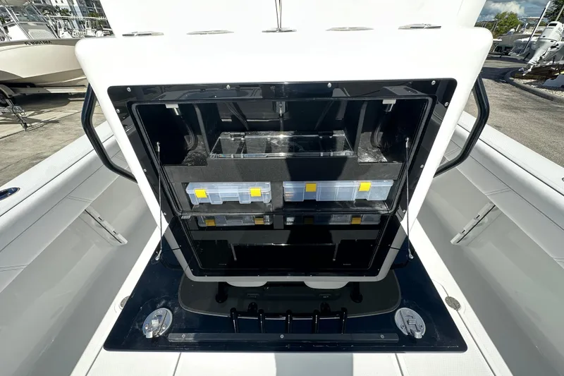 Slide: The Image of 2026 Bluewater 25t boat storage compartment with organized tackle boxes and equipment. - 19