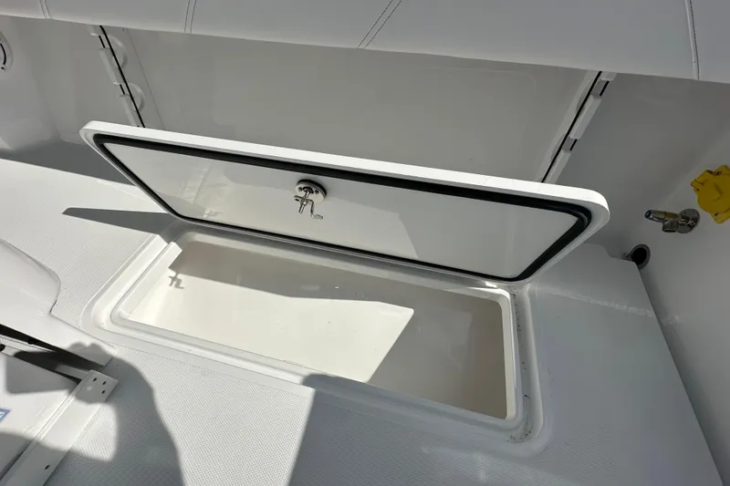 Slide: The Image of Open storage compartment on 2026 Bluewater 25t boat, featuring a secure latch and clean interior. - 20