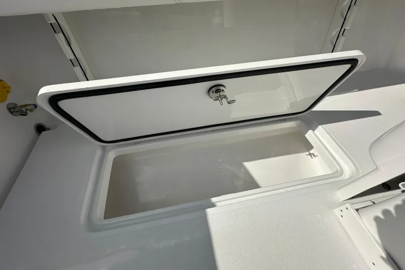 Slide: The Image of Open storage compartment on 2026 Bluewater 25t boat, featuring a secure latch. - 21