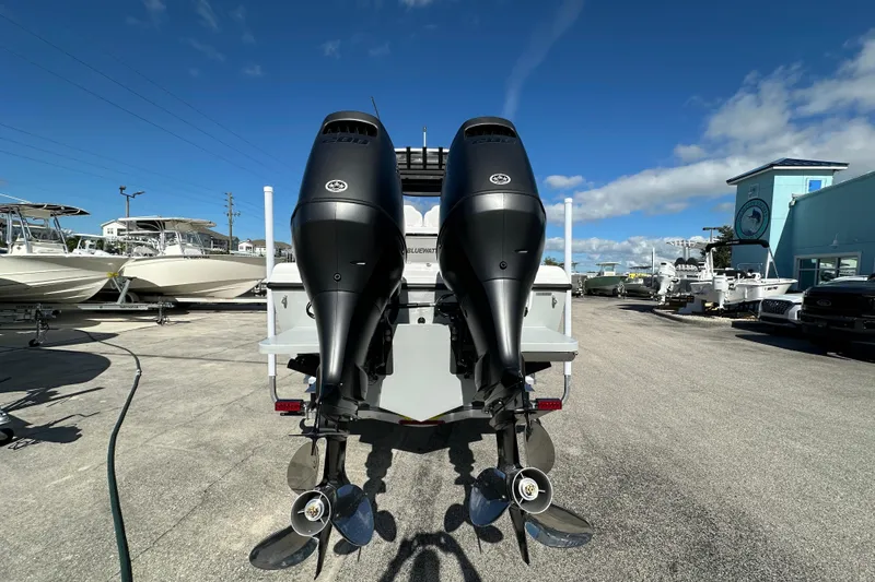 Slide: The Image of 2026 Bluewater 25t boat with dual outboard motors in a sunny marina. - 3