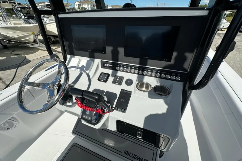 Slide: The Image of 2026 Bluewater 25t boat dashboard with steering wheel, dual screens, and control panel. - 6