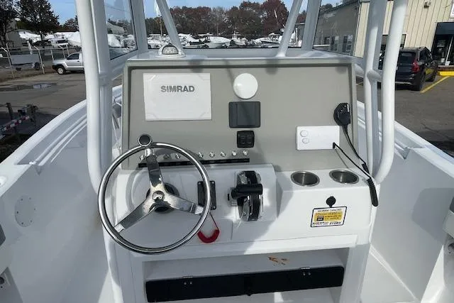 Slide: The Image of Center console of 2021 Release 210 RX boat with steering wheel and Simrad display. - 11