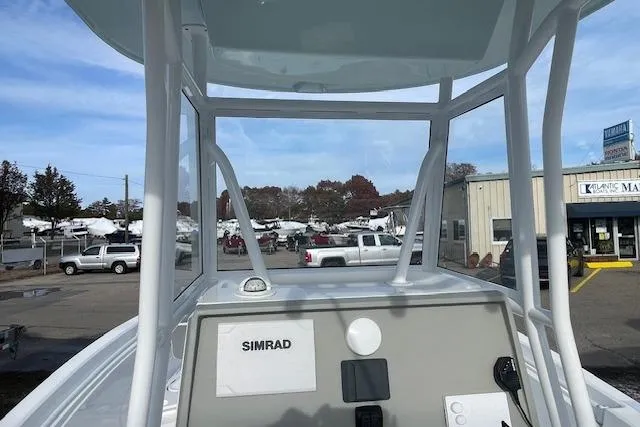 Slide: The Image of 2021 Release 210 RX boat with Simrad navigation, parked at a marina with vehicles and buildings. - 12