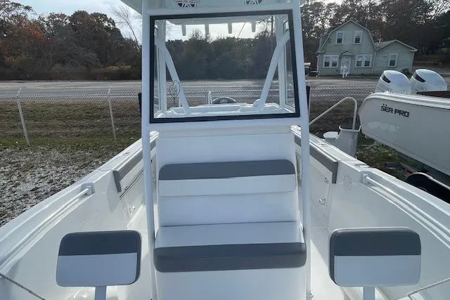 Slide: The Image of 2021 Release 210 RX boat interior with seating and console, parked outdoors. - 16